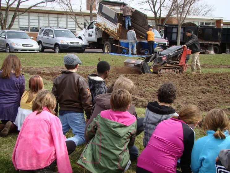  Fifth graders look on with curiosity as Daniel’s Garden Center tills our ground for a huge expansion of the Salford Hills fruit & vegetable garden.  